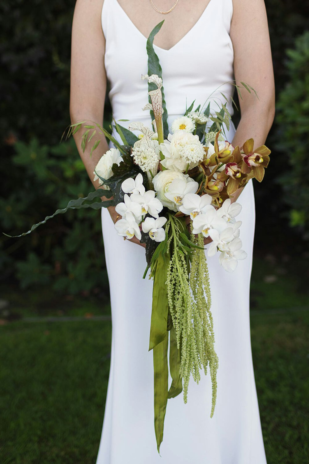 We're obsessed with this lush, orchid-forward bouquet—especially the vibrant draped greenery.
